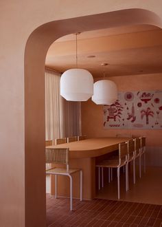 an archway leads into a dining room with two lamps hanging over the table and four chairs