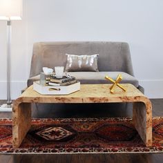 a living room with a couch, coffee table and rug in front of the wall