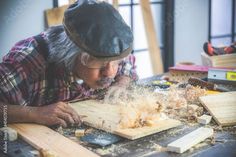 an older man is working on woodworking with his hands and face in the process