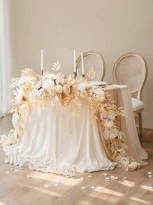 a table with flowers and candles on it in front of a window, surrounded by chairs