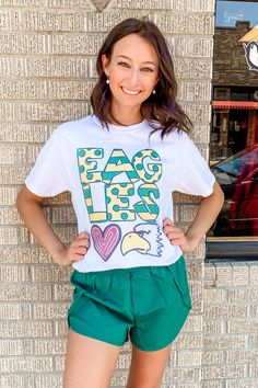 Rep your Eagles in this simple little white graphic with a fun hand drawn Eagles print across the front! Great for teachers, coaches, and students! unisex fit crew neck 50% cotton, 50% polyester Southern Roots Boutique112 W. Main St. Paragould, AR *Please allow 5-7 business days processing time for this item to be shipped/picked up. Fun Graphic Print T-shirt For College, Fun White Tops For Game Day, Casual White Sublimation Top With Letter Print, Casual Sports Apparel With Logo Print, Trendy White Top For Game Day, Casual Tops With Sublimation Print For Game Day, White School Spirit Top For Spring, Casual Sublimation T-shirt With Graphic Print Fan Merchandise, White Casual Sublimation Tee With Letter Print