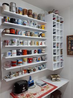 a white shelf filled with lots of different types of cups and saucers on top of it