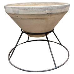 a large white bowl sitting on top of a metal stand