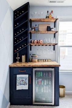 a small bar in the corner of a room with wine glasses and bottles on it