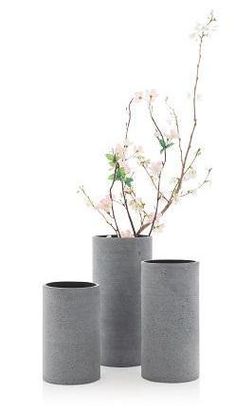 three grey vases with flowers in them on a white background, one is empty