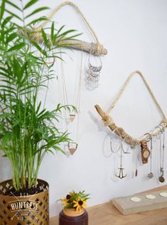 a potted plant sitting on top of a wooden table next to a wall hanging