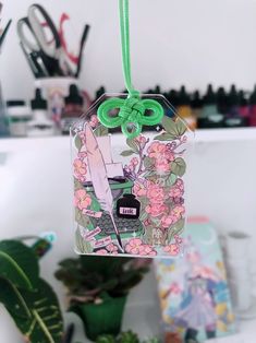 an ornament hanging from a green string with flowers and arrows on the front