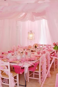 a room filled with tables and chairs covered in pink decorations