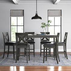 a dining room table with six chairs and a potted plant