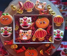 an assortment of decorated cookies in a box on a table with other decorations around it