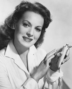 an old black and white photo of a woman holding a baseball bat in her right hand