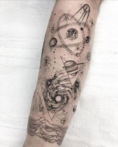 a person with a tattoo on their arm that has planets and stars in it,