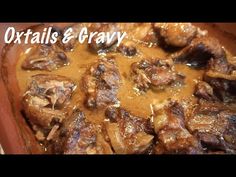 a close up of food in a pan on top of a table with the words oxtails and gravy above it