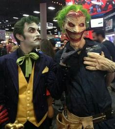 two men dressed up as joker and mad clowns at an convention or show in costume