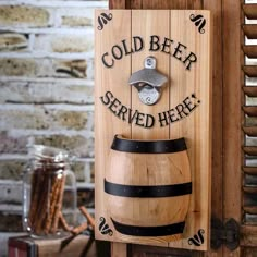 a wooden sign that says cold beer served here on the side of a barrel with a bottle opener