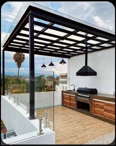 an outdoor kitchen is shown with grills on the outside and wood floors in front