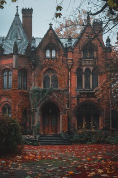 an old brick building with ivy growing on it's roof and stairs leading up to the front door