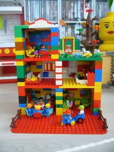 a toy house made out of legos on display in a room with other toys