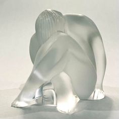 a white glass sculpture sitting on top of a table