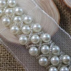 some white pearls are sitting on a piece of fabric