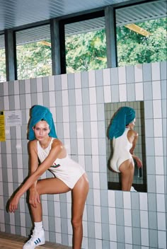 a woman in a bathing suit leaning against a wall