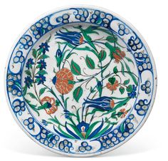 a blue and white plate with flowers on it's rim, in the shape of a flower