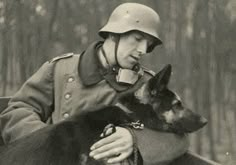 a man in uniform holding a german shepard dog