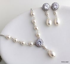 "This timeless pearl set has necklace and earrings with cubic zirconia stones and Austrian pearls in cream.  Please choose option at checkout set or individual pieces.   Necklace measures approximately 17\" long.  It's hand linked with 6 mm pearls. Pendant dangles  just over 1 1/4\" including the teardrop by 1/2\" in diameter.  Finished off with a lobster claw closure and 2\" extender chain for additional length. Dangle earrings are about 1 1/2\" long from top to bottom.  Each cubic zirconia stud is about 1/2\" in diameter. Perfect for a classy bride or any special occasion! **If your dress is ivory I recommend the white color in my opinion it is an off white and works with white and ivory gowns. The cream works with cream, light cream and some champagne shades. If you need help deciding t Pearl Wedding Jewelry Sets, Bridal Bracelet Pearl, Crystal Pearl Earrings, Backdrops Necklace, Bridal Pearl Necklace, Wedding Jewelry Set, Bridal Jewelry Set, Pearl Necklace Set, Bridal Earrings Pearl