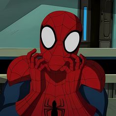 the spider - man is sitting in front of a computer screen with his hands on his face