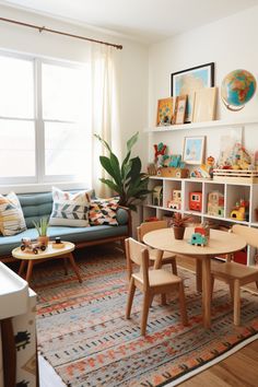 a living room filled with furniture next to a window and a rug on top of a wooden floor