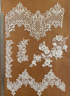 several pieces of white lace on brown paper