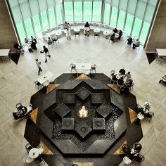 an overhead view of people sitting at tables in a large room with high ceilings and floor to ceiling windows