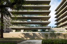 an apartment building with many balconies and plants growing on the side of it