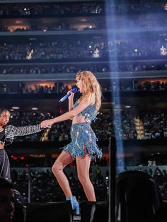 two women on stage with one holding a microphone