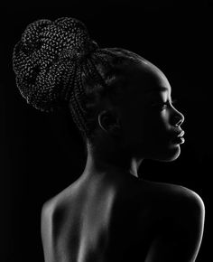 a woman with braids in her hair looking off to the side, black and white photograph