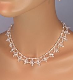 "This Bridal Beaded Snowflake Statement Necklace is The Rochelle. You will receive the necklace and earrings. This is the perfect Winter Wedding jewelry set. The Rochelle is a lace like necklace that adds just the right amount of sparkle for a bride who's style is elegant and \"middle of the road\"  but still wants to make a statement.  This is created with 4mm Swarovski clear crystals, 4mm Swarovski pearls and clear seed beads. It is 19\" in length and has a solid sterling silver clasp. The matching earrings have a 6mm pearl topped with a 5 mm crystal and a 4mm pearl. The ball hook earring wires are solid sterling silver. This exact set is ready to ship and this is the last one I will be making. I am in AZ so it is usually 2 days to either coast, but allow more time just in case. If you a Winter Wedding Jewelry, Beaded Bridal Jewelry, Unique Wedding Jewelry, Wedding Jewelry Set, Snowflake Necklace, Wedding Bridesmaid Jewelry, Winter Bride, Lace Necklace, Wedding Winter