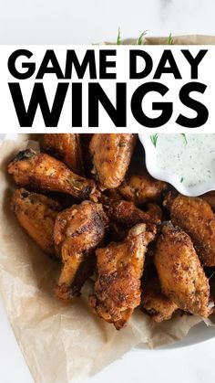 a white plate topped with chicken wings covered in ranch dressing and the words game day wings