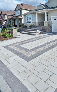 a driveway with steps leading up to the front door and two garages behind it