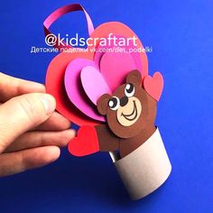 someone is holding up a paper flower with a monkey on it's head in front of a blue background