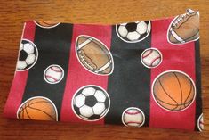 a red and black purse with sports balls on it