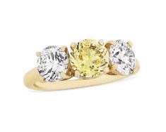 This classic three-stone ring from the celebrated house of Cartier is set with three extraordinary stones. At its center rests a round brilliant-cut fancy vivid yellow diamond weighing 1.24 carats. Certified by the Gemological Institute of America (GIA), the colored gemstone displays VS1 clarity with excellent polish and even color distribution. Two white diamonds totaling 1.80 carats flank the yellow diamond, and each is equally exceptional in quality. The GIA has certified both stones as posse Golconda Diamond, Yellow Diamond Ring, Three Stone Diamond Ring, Yellow Diamond Rings, Three Stone Diamond, Three Stone Ring, Fine Jewels, Three Stone Rings, Classic Ring