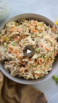 a white bowl filled with coleslaw and carrots next to a jar of mayonnaise