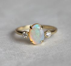 Buy gold opal ring and opal engagement rings. We offer a beautiful oval opal ring with two diamonds on the side at best prices. Shop Now! FREE shipping worldwide! Oval Opal Ring, Engagement Ring Opal, Gold Opal Ring, Opal And Diamond Ring, Opal Diamond Ring, October Birthstone Rings, Opal Engagement Ring, Ring Opal, Opal Ring Gold