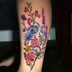 a colorful flower tattoo on the leg