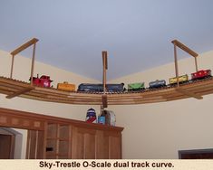 a toy train set is sitting on a wooden track in the corner of a room