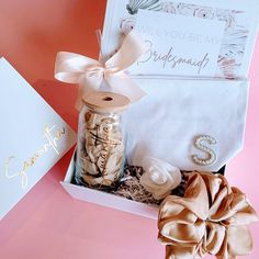 a gift box with jewelry and a note on the side, sitting next to it