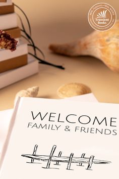 an open book sitting on top of a table next to a stack of books with the words welcome family and friends