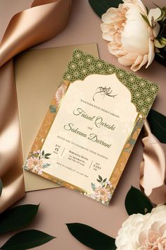 a wedding card with flowers and satin ribbon on it next to a bouquet of peonies