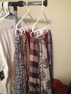 several scarves are hanging on a clothes rack