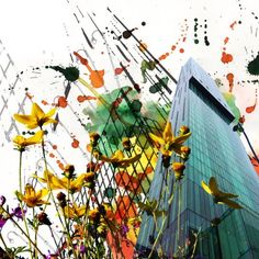 the building is surrounded by colorful flowers and paint splattered on it's sides